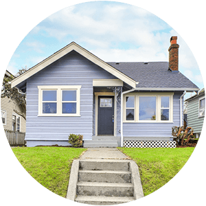 Photo of small blue house with green lawn